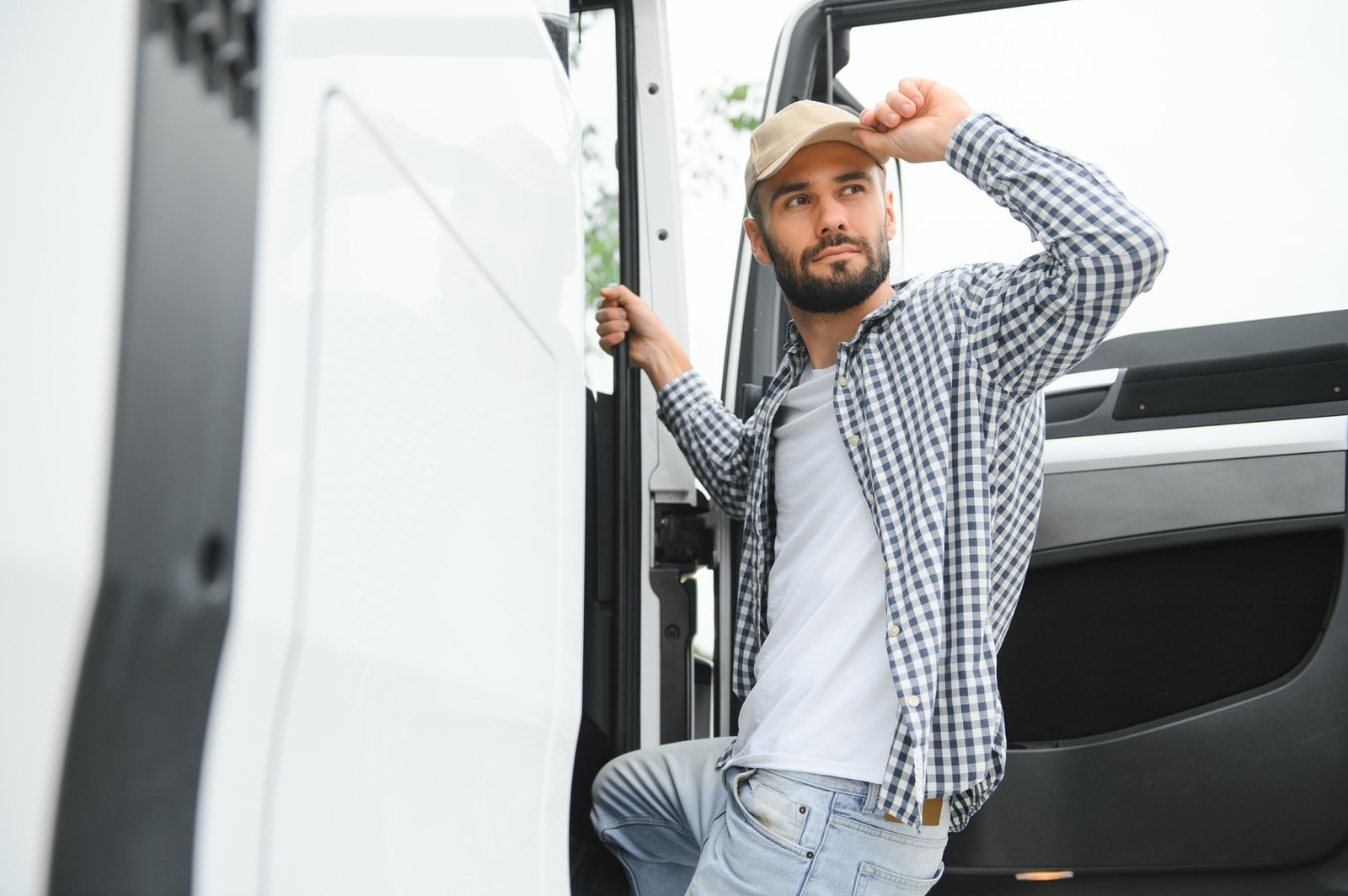 Truck driver climbing into cab of semi-truck Truck driver climbing into cab of semi-truck