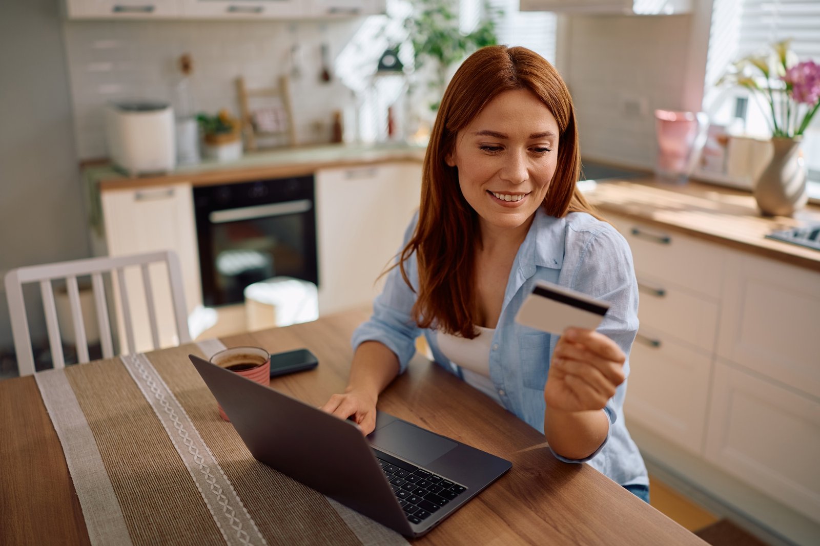 Happy woman checking her bank account online at home.