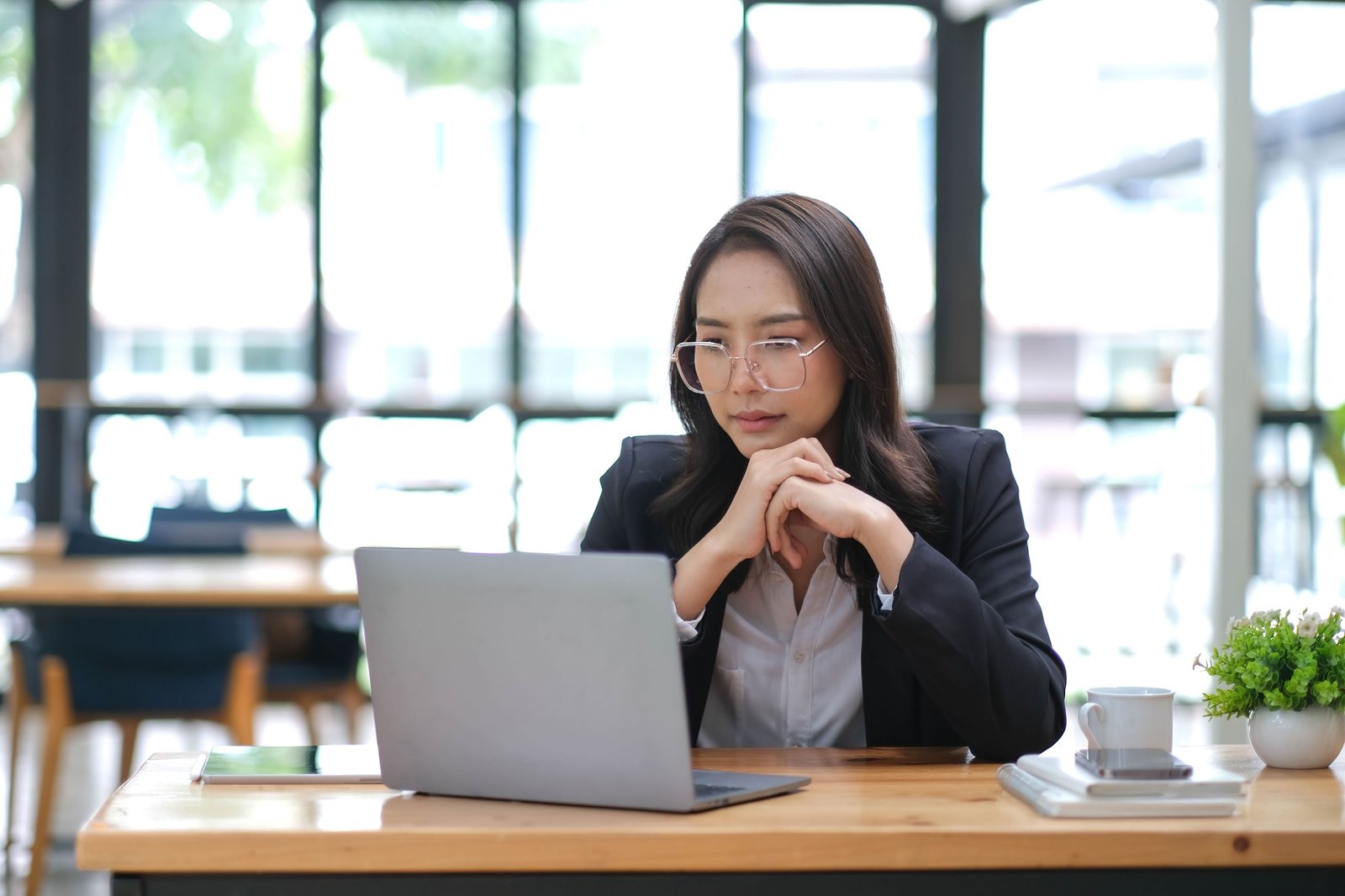 Professional Asian businesswoman or female manager is pensively thinking about a business plan or