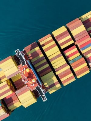 Aerial top view of cargo ship carrying container and running for export goods from cargo yard