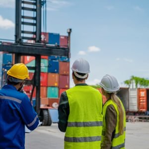 foreman are discussing for stack container at cargo site logistics service transportation.