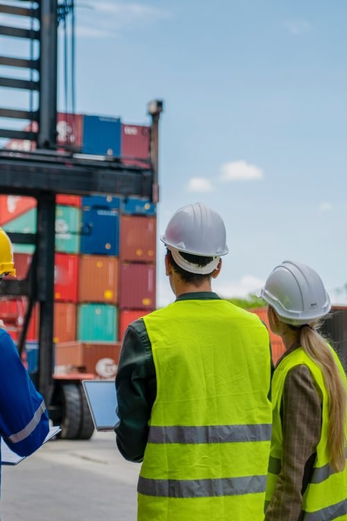 foreman are discussing for stack container at cargo site logistics service transportation.