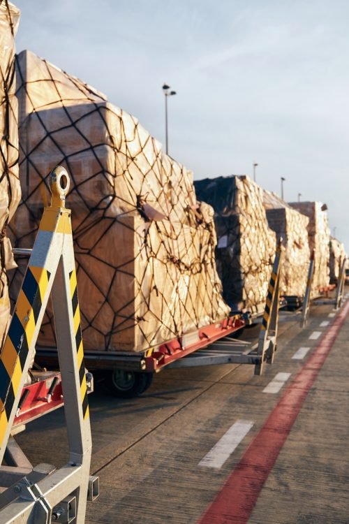 Loading of cargo containers to airplane at airport.